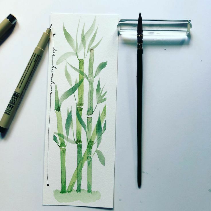 a watercolor painting of green bamboo plants and a fountain pen on a white surface