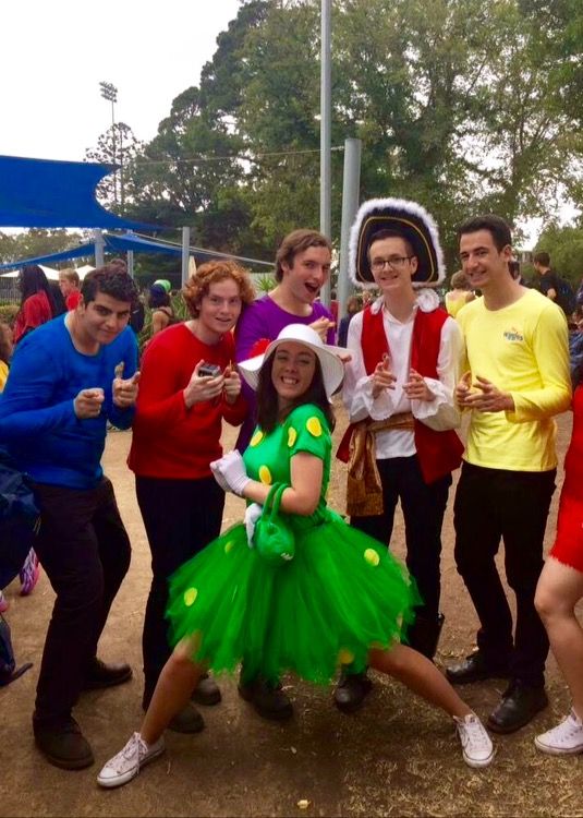 a group of people dressed in costumes posing for a photo at an outdoor event together