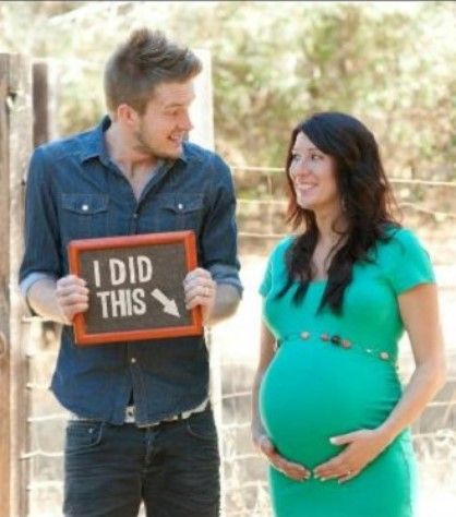 a pregnant couple holding up a sign that says i did this