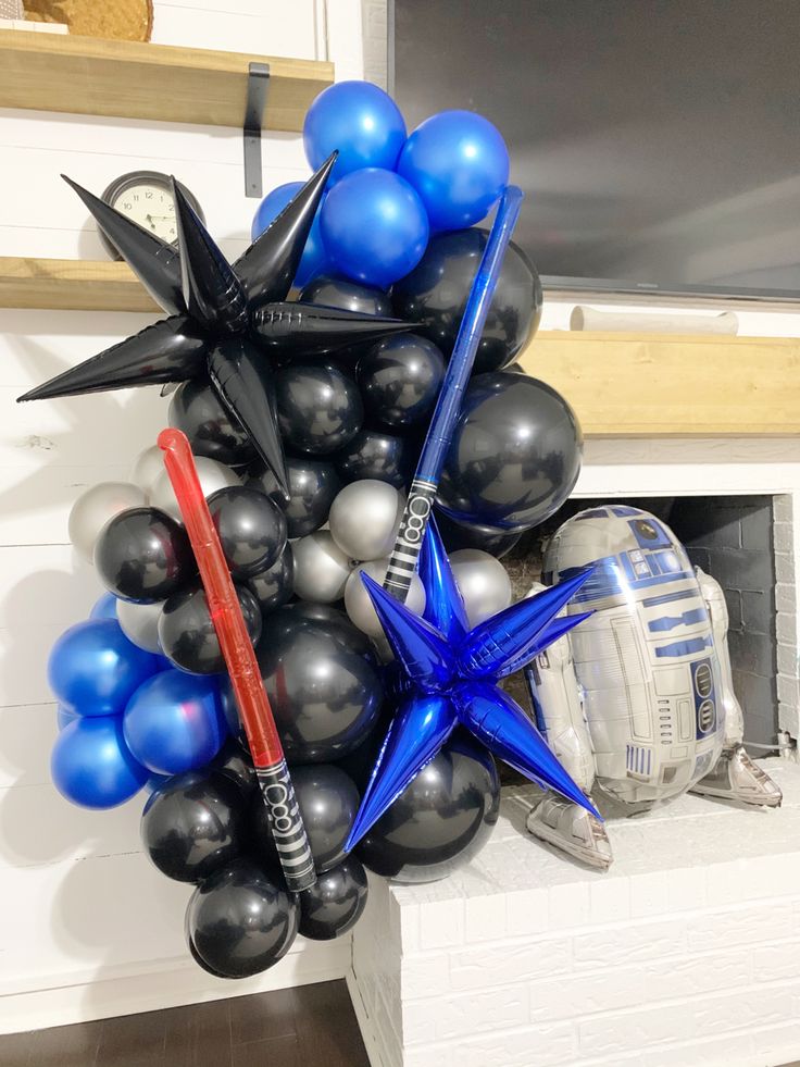 a bunch of balloons that are in the shape of star wars characters on a fireplace mantel