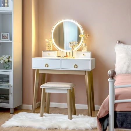 a bedroom with a bed, mirror and stools in front of the dresser table