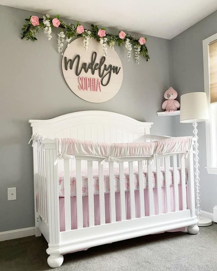 a white crib in a gray and pink nursery