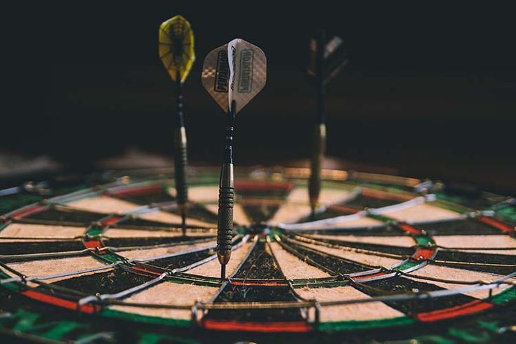 three darts are in the middle of a dart board that has been placed on top of it