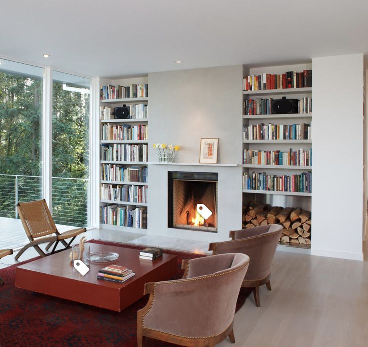 a living room filled with furniture and a fire place in front of a book shelf