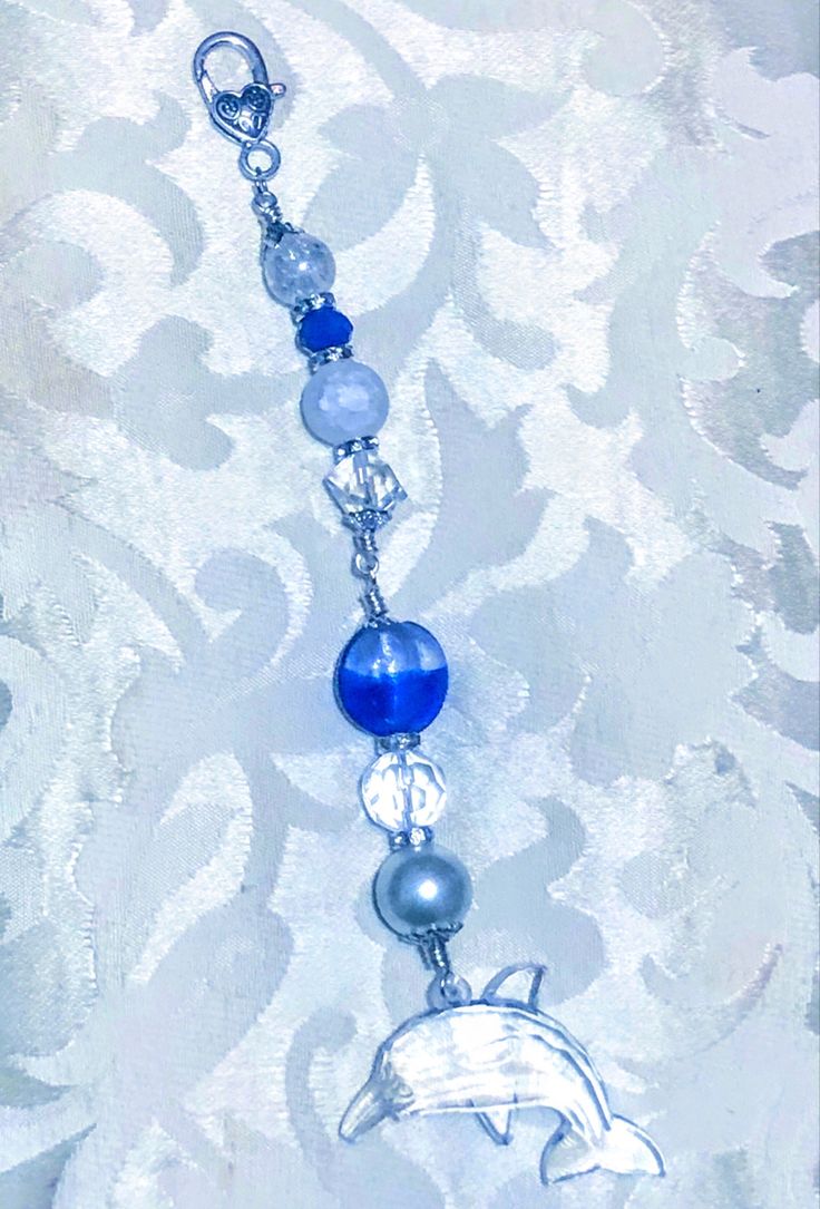 a blue and white beaded necklace with a dolphin on it