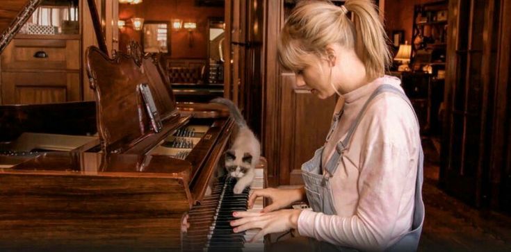 a woman is playing the piano with her dog