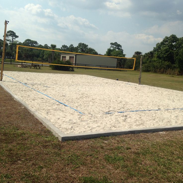 an empty volleyball court in the middle of a field