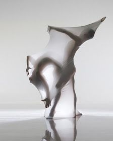 an abstract sculpture is shown on the floor with its reflection in the water and it's surface