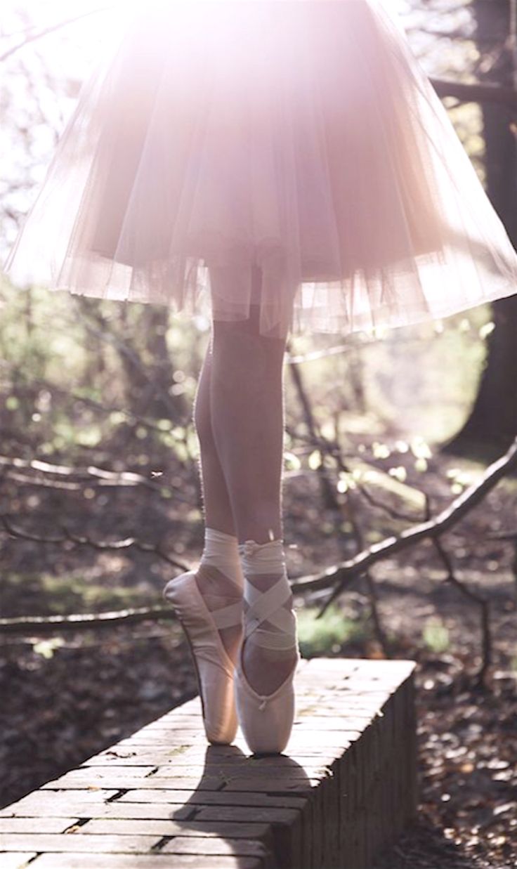 a woman is standing on a wooden platform in a skirt and heels with her legs crossed