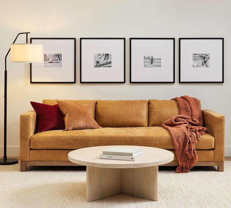 a living room filled with furniture and pictures on the wall above it's coffee table