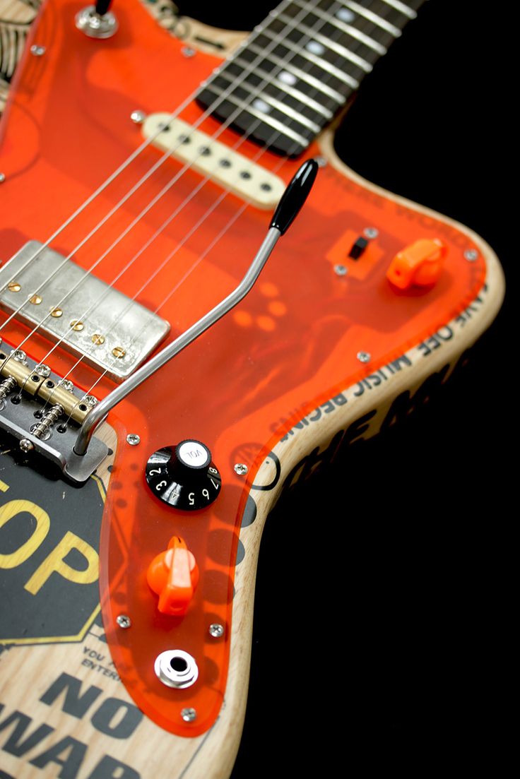 an orange electric guitar sitting on top of a table