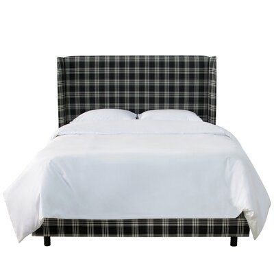 a bed with white sheets and black plaid headboard on it's side, in front of a white background