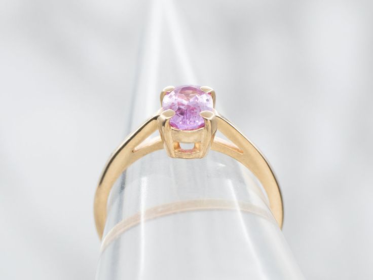 This ring's focal point is the sweet cherry blossom pink sapphire set at the center! The simple engagement mounting, with balanced shoulders and high-mounted prongs, is the perfect frame for this stunning stone and will sit nicely next to a variety of wedding band styles. Metal: 14K Yellow GoldGem: Pink Sapphire .99 CaratsGem Measurements: 4.8 x 6.9 mm, OvalRing Size: 6Marks: "14K*" Stamped on the inside band Pink Brilliant Cut Amethyst Wedding Ring, Wedding Pink Brilliant Cut Amethyst Ring, Elegant Pink Sapphire Round Band Ring, Pink Brilliant Cut Round Amethyst Ring, Pink Amethyst Ring With Brilliant Cut, Pink Brilliant Cut Amethyst Ring, Fine Jewelry Pink Sapphire Solitaire Rings, Pink Sapphire Ring With Round Cut Center Stone, Pink Sapphire Ring With Center Stone