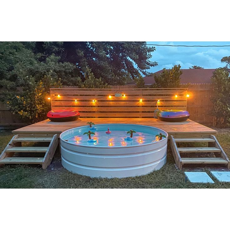 an above ground pool surrounded by wooden pallets with lights on the side and steps leading up to it