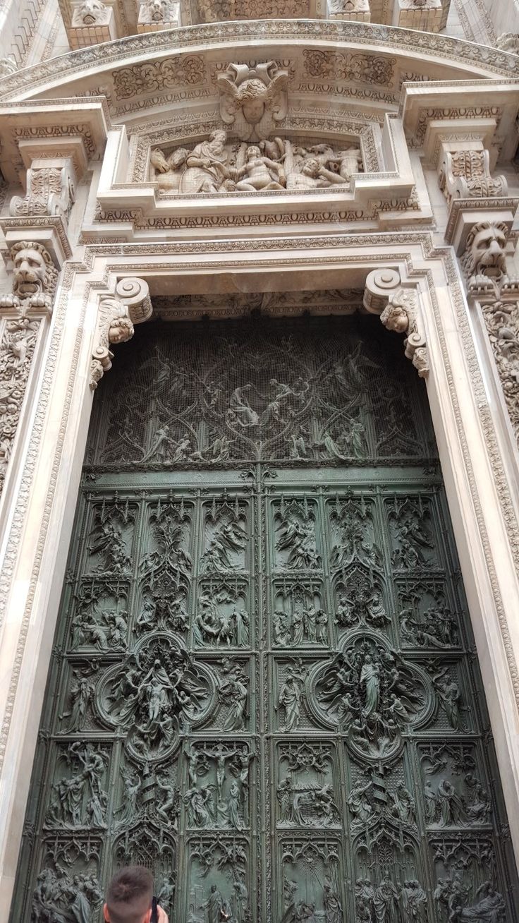 a man standing in front of an ornate door