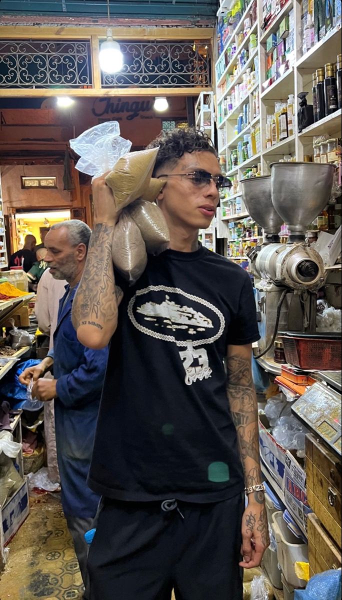 a man with tattoos is walking through a store