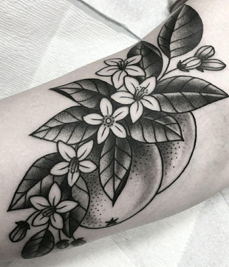 a black and white flower tattoo on the arm