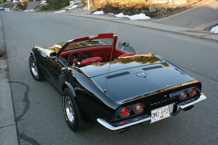 an old black car parked on the side of the road