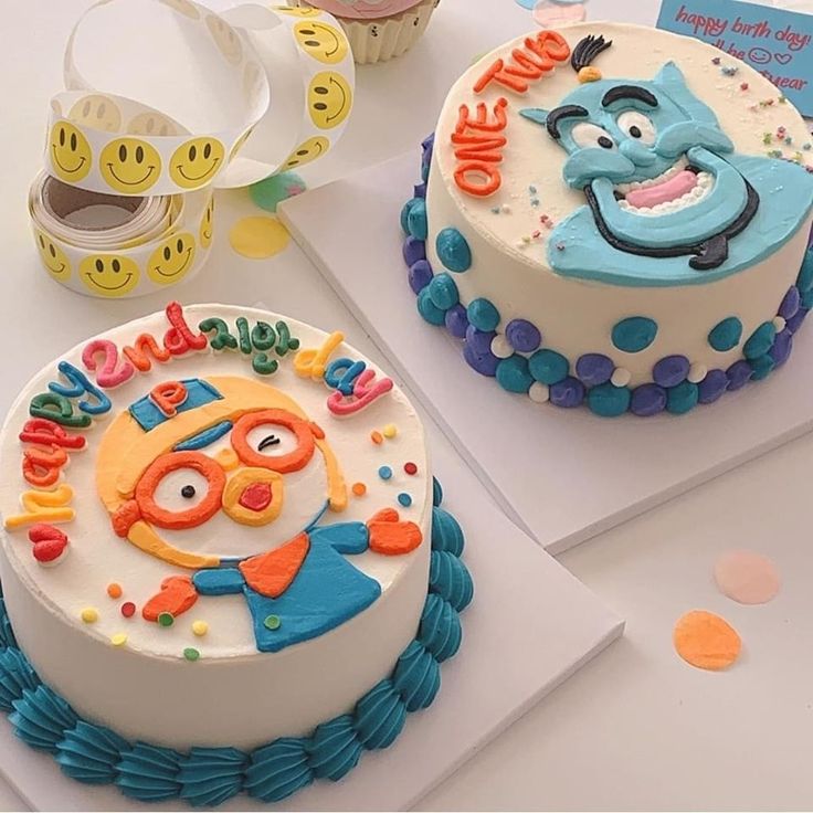 two decorated birthday cakes sitting on top of a table