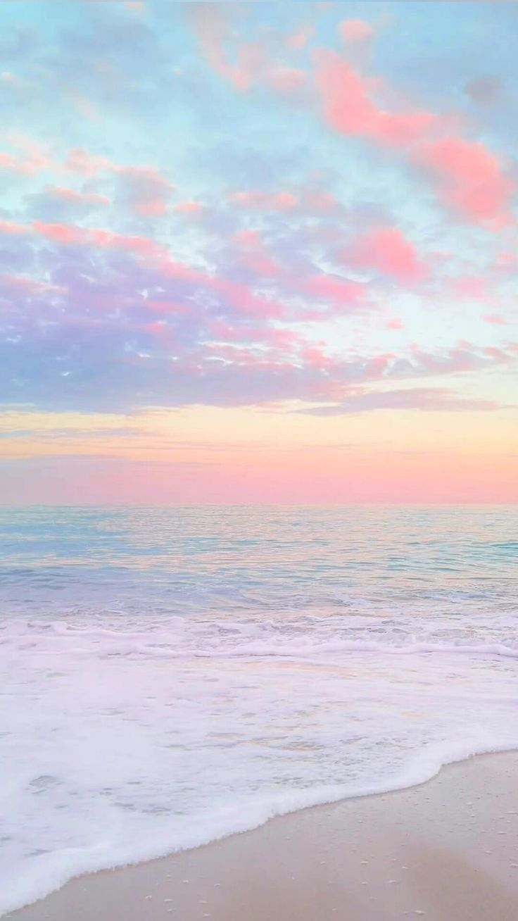 an ocean beach with waves coming in to shore and the sky painted pink, purple and blue