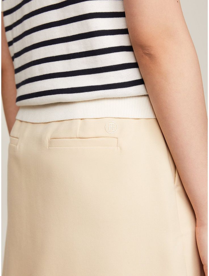 Tommy Hilfiger women's skirt. This mini skirt combines a playful silhouette with sophisticated details, such as understated logo embroidery above the back pocket.  Material: 66% Recycled Polyester (rpe), 32% Viscose (scv), 2% Elastane. Classic Summer Mini Skirt For Workwear, Classic Summer Mini Skirt For Work, Elegant Workwear Shorts With Lined Skirt, Classic Beige Pencil Skirt Bottoms, Classic Spring Pencil Skirt Skort, Classic Spring Skort, Classic Beige Lined Skirt, Elegant Beige Short Skort, Classic Mini Length Lined Bottoms