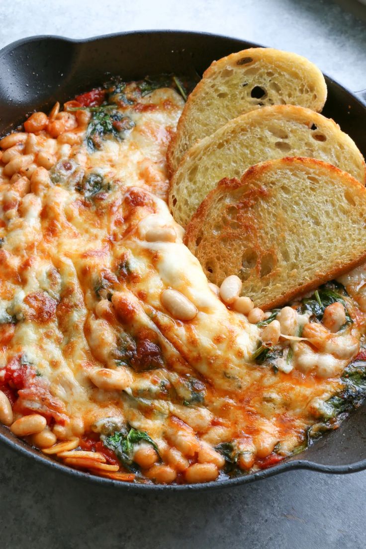 a skillet filled with baked beans and bread