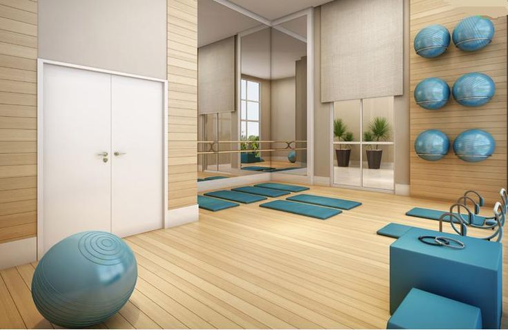 a room filled with yoga mats and blue balls on top of it's floor