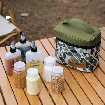 several bottles and containers sitting on a wooden table with a cooler bag in the background