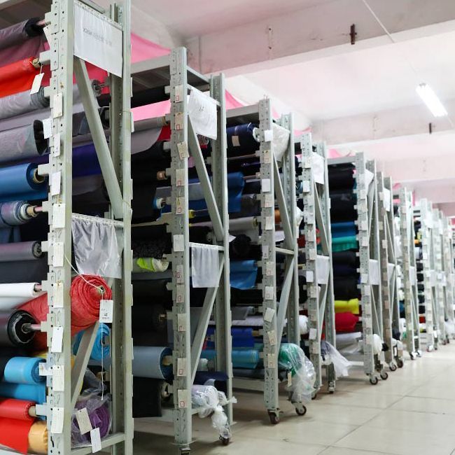 a rack full of different colored fabrics in a room with tile flooring and walls