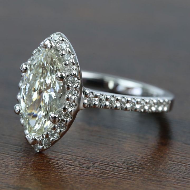 an oval cut diamond ring sitting on top of a wooden table