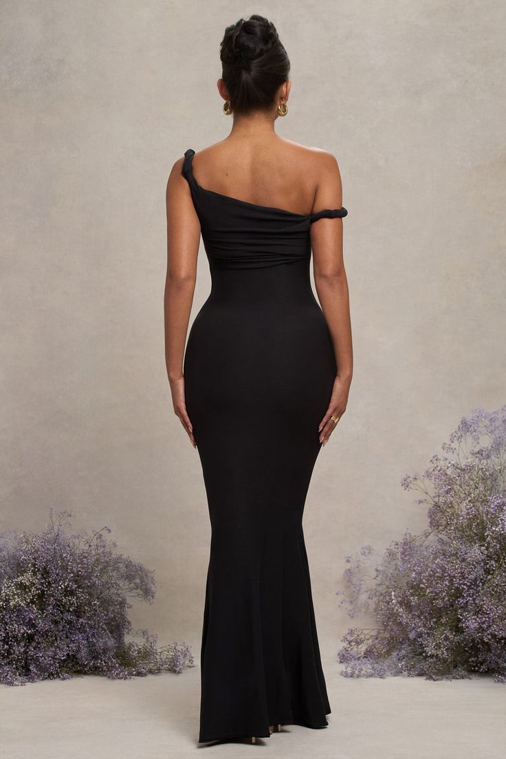 a woman in a black dress looking back