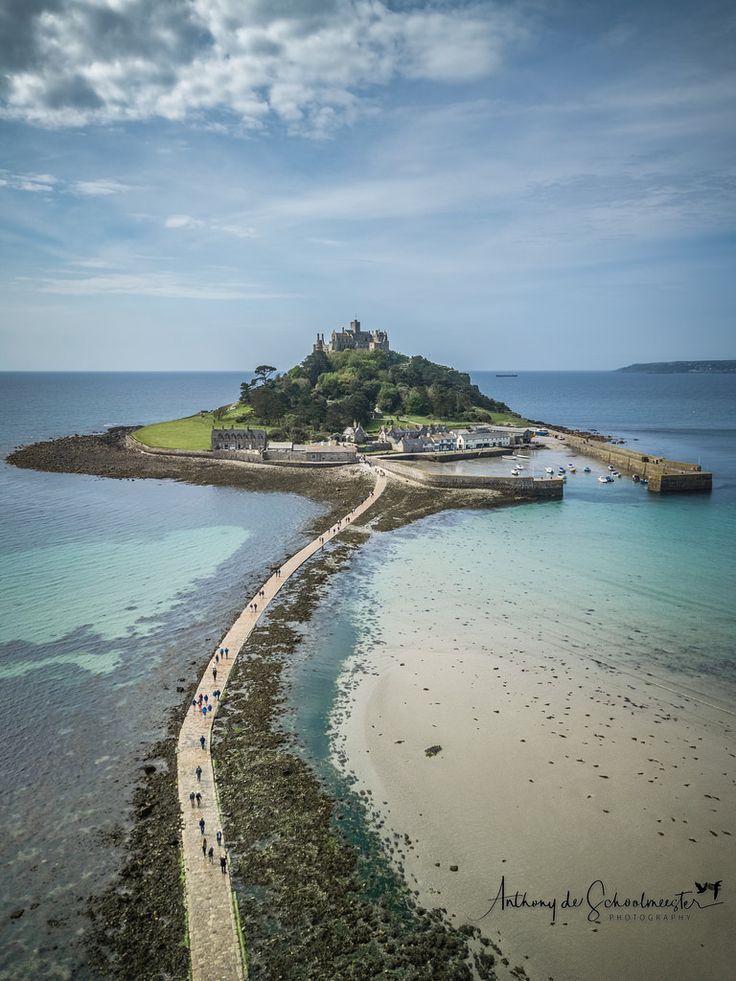 an island with people walking on it near the water and in the distance is a beach