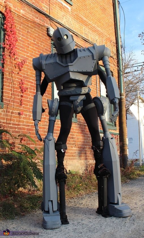 a large robot standing in front of a brick building