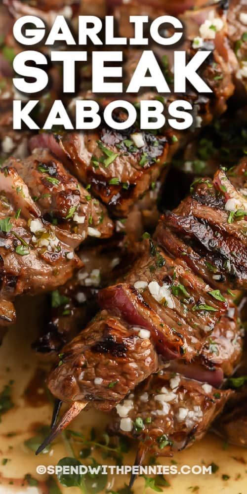 grilled steak kabobs with garnish on top and the title overlay reads garlic steak kabobs