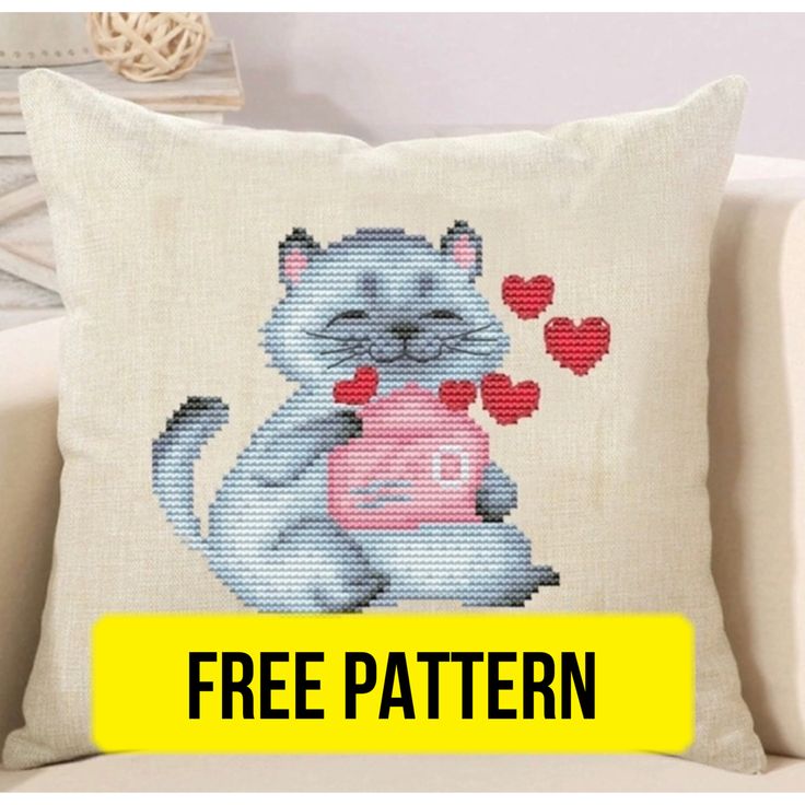 a cross stitch pillow with a cat holding a heart in it's paws and the text free pattern