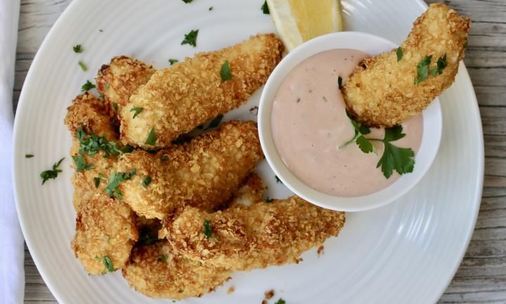 some fried food on a white plate with dipping sauce