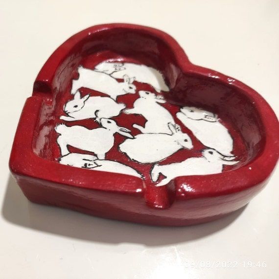 a red heart shaped box with white rabbits on it