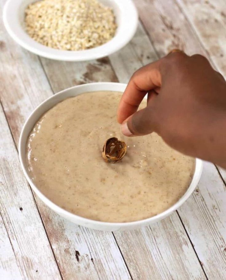 someone is dipping something into a bowl of oatmeal