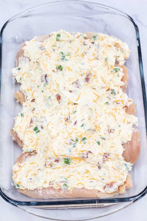 a casserole dish with cheese and other toppings in a glass baking dish