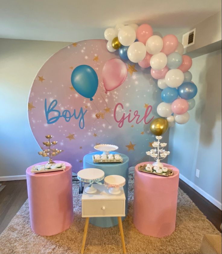 a baby girl party with balloons and decorations on the wall, including pink stools