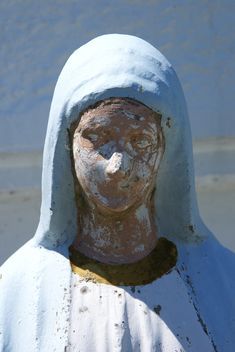 a statue of a woman wearing a blue headdress and a white shawl