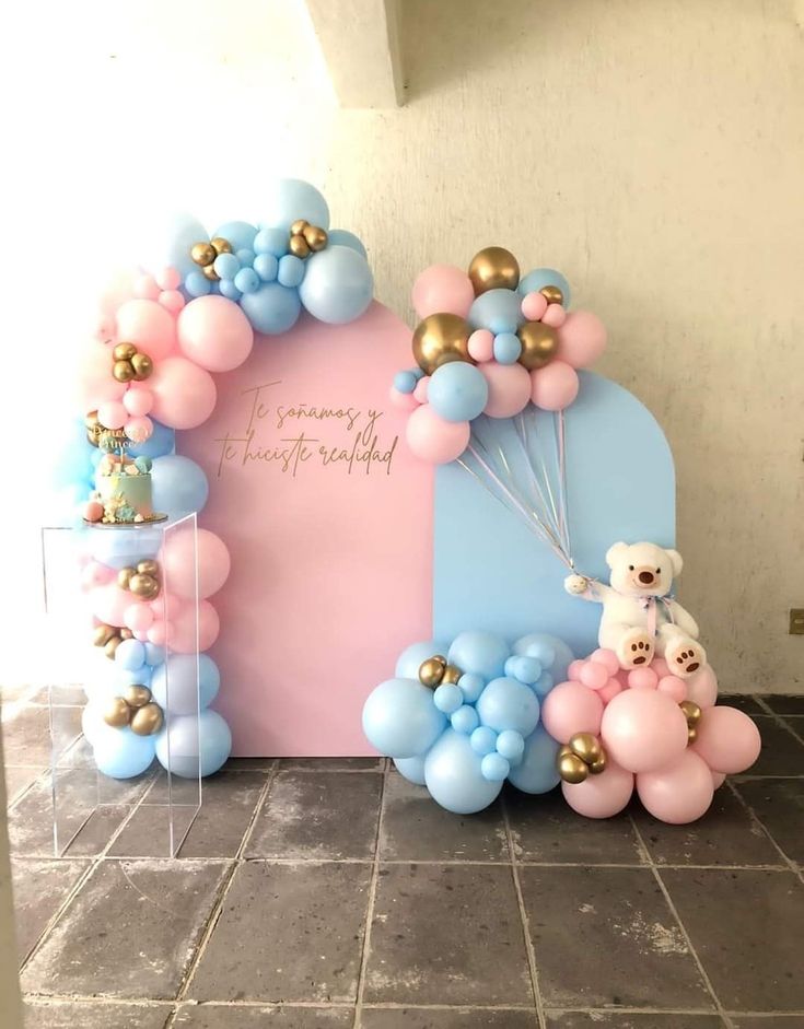 balloons and teddy bears are on display in front of a pink backdrop with gold accents