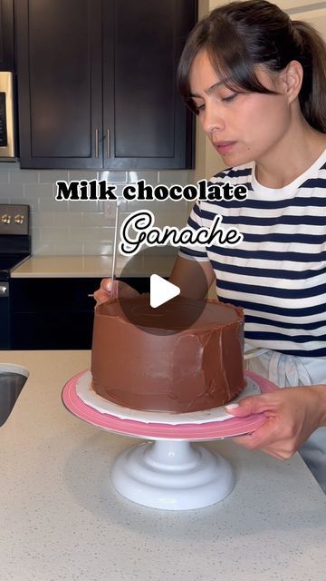 a woman is decorating a cake with chocolate icing on the top and bottom