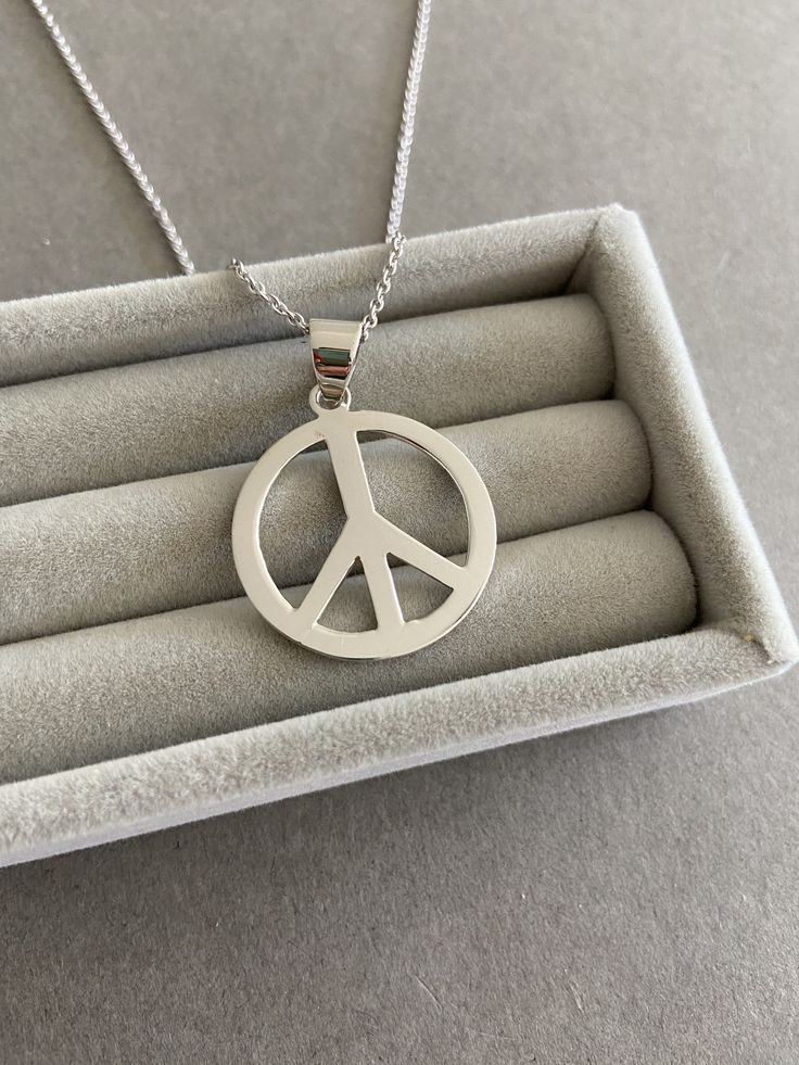 Silver Peace Sign Necklace - Sterling Silver ★ Quantity: One ★ Color : Silver ★ Material : Sterling Silver ★ Peace Size : 25mm ★ Chain Length : 18 inches / 20 inches * Metal components are Sterling Silver. * Suitable for delicate and sensitive skin. * Comes in a jewelry box. If you need extra boxes for gifting....just let us know! Silver Peace Sign Jewelry Gift, Adjustable Sterling Silver Peace Sign Jewelry, Adjustable Peace Sign Necklace As Gift, Adjustable Peace Sign Necklace, Symbolic Hypoallergenic Necklace With Round Pendant, Symbolic Silver Jewelry With Peace Sign, Peace Sign Jewelry For Gifts, Cadmium-free Round Stainless Steel Necklace, Trendy Nickel Free Round Pendant Necklace