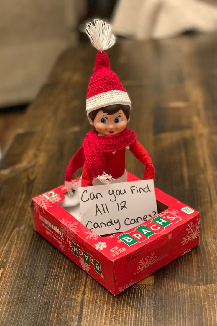 an elf is sitting on top of a candy box with a sign that says, can you find all of candy candy?