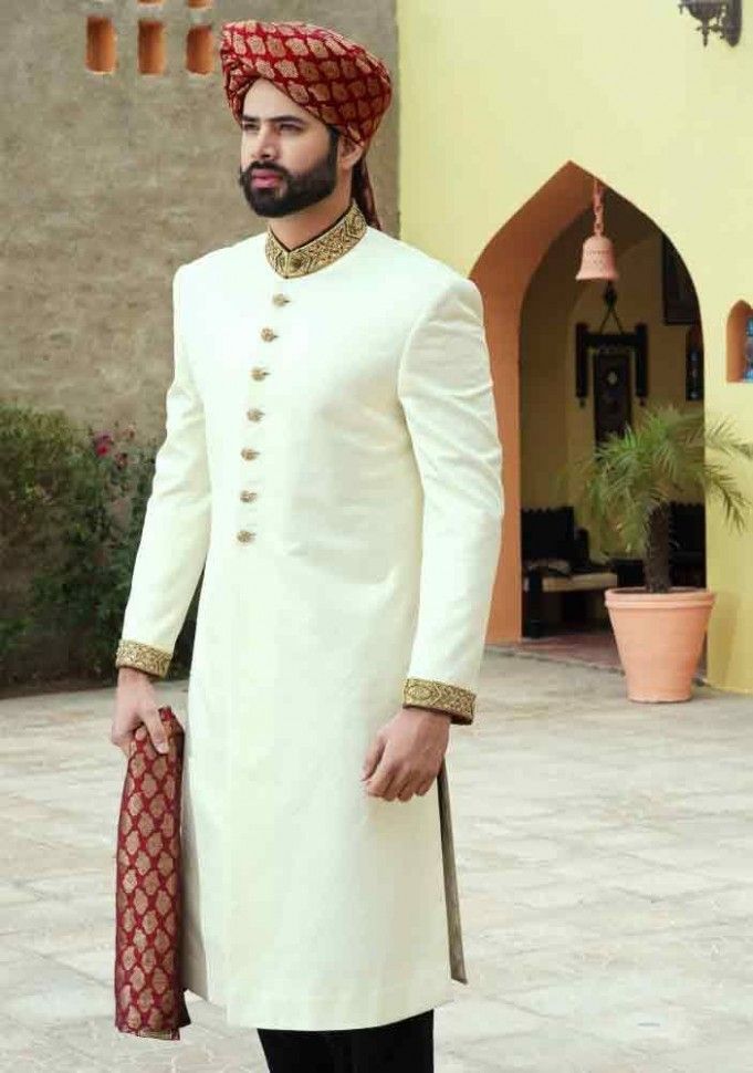 a man wearing a white sherwa with red and gold details