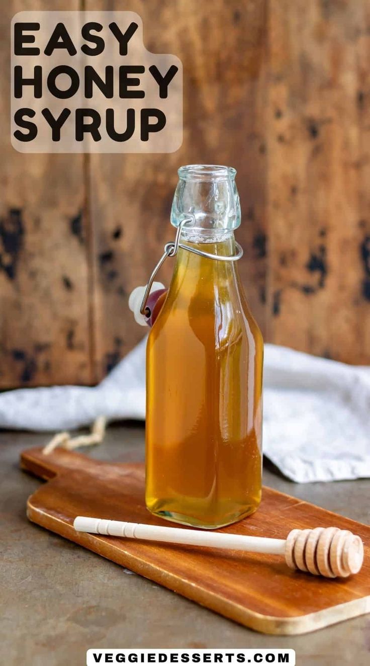 a bottle of honey syrup on a cutting board next to a wooden stick and napkin