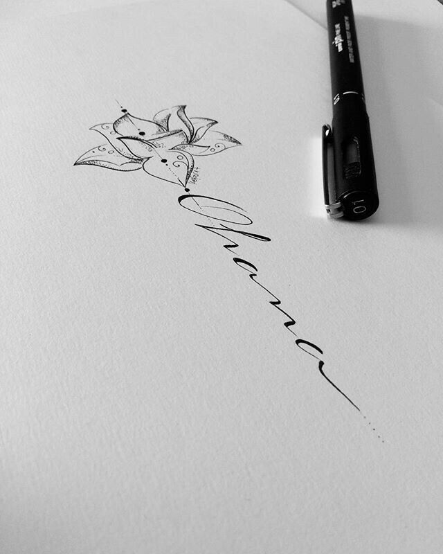 a pen sitting on top of a piece of paper next to an ink drawing flower