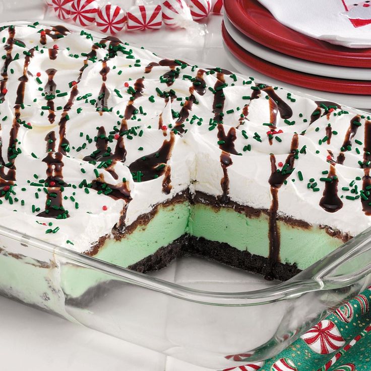 a cake with white frosting and green sprinkles on it sitting in a glass dish