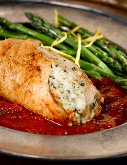 a close up of a plate of food with meat and asparagus on it